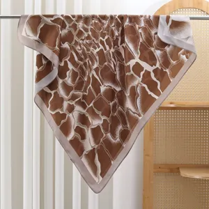 Close-up detail of brown square silk scarf with abstract cracked pattern hanging on rod.