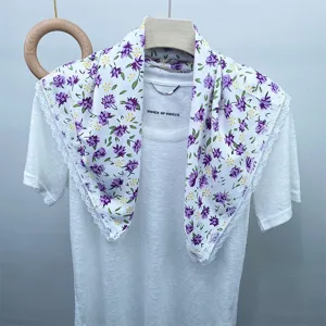 Detailed view of the white floral silk scarf with delicate lace edge, elegant purple flower print.
