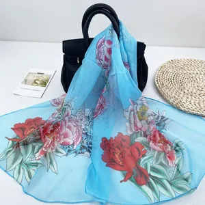 Detailansicht eines hellblauen Damen Chiffonschals mit elegantem Pfingstrosenmuster im Frühling.