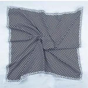 Close-up detail of black and white checkered square scarf with delicate white lace trim.