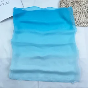 Close-up of lightweight blue gradient chiffon scarf, soft breathable fabric for summer.