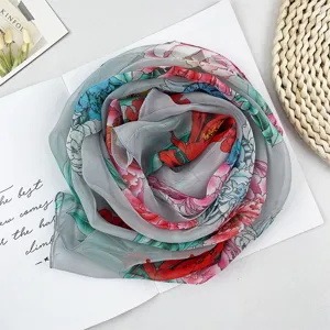 Nahaufnahme Detail des grauen Georgette Langschals mit buntem Pfingstrosen Blumenmuster.