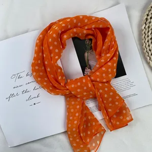 Close-up detail of the orange georgette scarf featuring white polka dots, lightweight and airy.