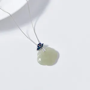 Detailed close-up of jade ruyi pendant with silver chain and enamel lotus bail design.