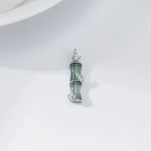 Primo piano dettagliato dell'elegante ciondolo di giada bamboo con diamanti splendenti.