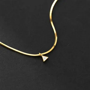 Exquisite gold snake chain necklace with a chic triangle crystal pendant close-up view.
