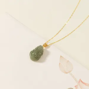 Primer plano detallado de un colgante Pi Xiu de jade Hotan en cadena dorada con tarjeta.
