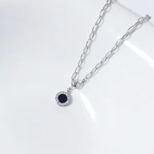 Vue détaillée du collier pendentif onyx noir chiffres romains argentés chaîne fine.