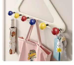 Close-up of modern dopamine style wall mounted coat rack with colorful ball hooks for entry.