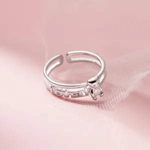 Detalle de anillo de doble capa de plata, dije de oso tierno y texto grabado lovely.