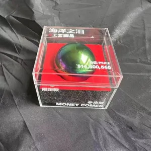 Primo piano della sfera decorativa iridescente lucida in una scatola di acrilico trasparente.