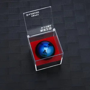 Modello di sfera riflettente blu in teca trasparente con base in velluto rosso per esposizione.