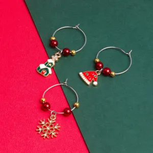 Christmas wine glass charms detail shot featuring cute house, hat, and snowflake metal pendants.