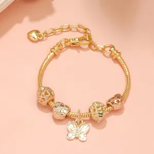 Detalles de la pulsera dorada con un dije de mariposa brillante y cuentas muy bonitas.