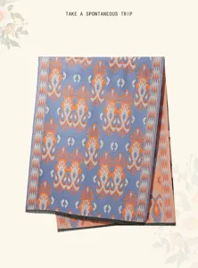 Detailed view of imitation cashmere scarf blanket with geometric ethnic pattern and black fringe.