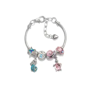 Silver snake chain charm bracelet detail featuring cute mermaid and sea turtle pendants.