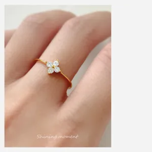 Gros plan détaillé de la fine bague trèfle en argent sterling avec des zircons brillants.