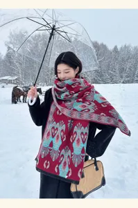 Detailed shot of a stylish winter cashmere-feel scarf shawl worn by model in snow.