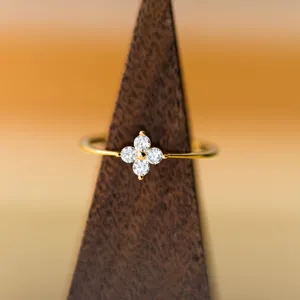 Détail de bague trèfle à quatre feuilles, design de bijoux minimaliste, accents de strass.