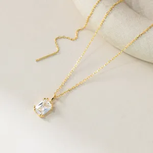 Primo piano di una delicata collana in argento bagnato oro con ciondolo rettangolare.