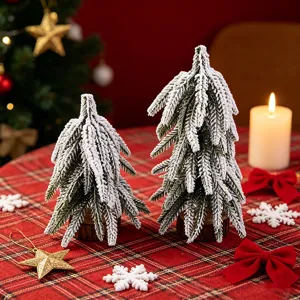 Close-up detail of frosted mini Christmas trees with wood base on red plaid fabric.