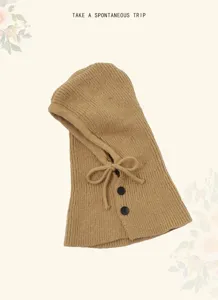 Close-up detail of knitted balaclava winter warm hooded scarf in khaki with buttons.
