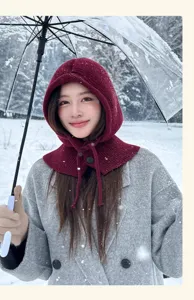 Detailed close-up of a maroon knitted balaclava hood in snowy outdoor scene.
