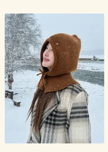 Detail view of the cozy brown knitted balaclava hood, winter warm outdoor snow scene style.