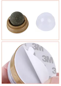 Detail view of rotating catnip ball pet toy with adhesive base and clear dust cover.