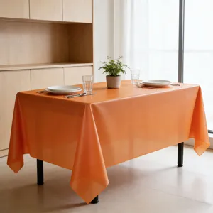 Vista dettagliata di una tovaglia neon arancione vivace su un tavolo da pranzo moderno.