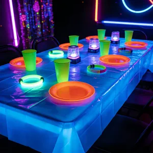 Dettaglio decorazione tavola festa neon con tovaglia fluorescente e accessori luminosi.