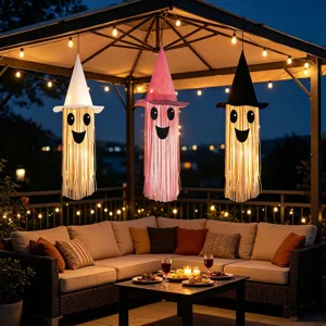Outdoor Halloween hanging ghost decoration scene detail showing glowing witch hat lights with streamers.