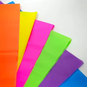 Dettaglio ravvicinato di tovaglie in plastica monouso fluorescenti disposte a ventaglio.