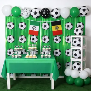 Voetbal feestversiering set met groen franje gordijn, ballonnen en tafelopstelling.