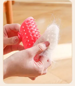 Close-up shot of a pink silicone pet hair removal brush showing easy fur cleaning process.