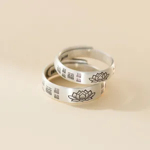 Close-up detail of vintage sterling silver couple rings with lotus and blessing characters.
