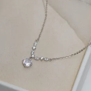 Detalle de collar de plata S925 en forma de V con colgante de circonita brillante.