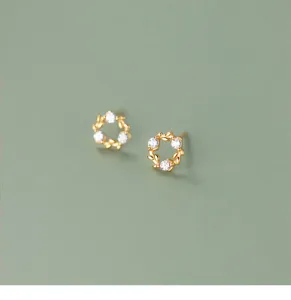 Closeup of exquisite gold-plated leaf wreath stud earrings inlaid with sparkling cubic zirconia.