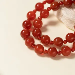 Detailansicht des exquisiten doppelten roten Achat-Perlenarmbands mit glänzenden Perlen.