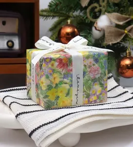 Exquisite floral gift wrapping box with elegant white ribbon bow, perfect for festive holiday.