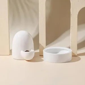 Vista in primo piano di un abbeveratoio e ciotola in ceramica bianca per piccoli animali domestici.