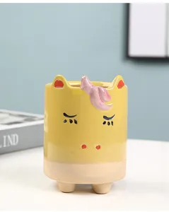 Detail shot of cute ceramic succulent planter featuring unicorn design with sleeping facial expression.