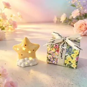 Ceramic star night light detail view showing the glowing warm light holes and cute cloud base design.