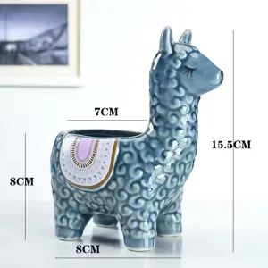 Close-up detail of the blue ceramic alpaca succulent plant pot with cute embossed texture.