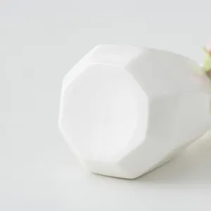 Nahaufnahme der weißen Keramik-Mini-Vase mit geometrischem Design und feiner Oberflächentextur.
