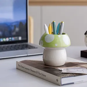 Detailopname keramische paddenstoel penhouder op een schoon bureau in minimalistische stijl.