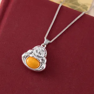 Close up detail view of a retro 999 sterling silver Maitreya Buddha pendant with yellow amber.