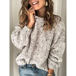Close-up detail of the chunky speckled knit sweater texture, casual long sleeve crewneck style.