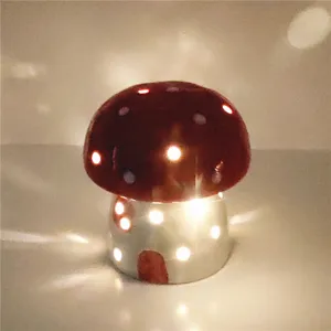 Close-up detail of a glowing ceramic mushroom night light with cute light spots in dark room.