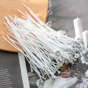 Nahaufnahme von weißen DIY-Duftkerzendochten mit Metallhalterungen, Baumwollschnüre.